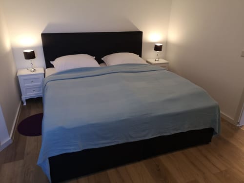 einfaches Doppelzimmer mit Nachttischen und Leselampe