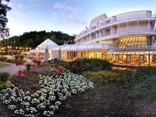 Ansicht der Hotels vom Garten aus bei Dämmerung