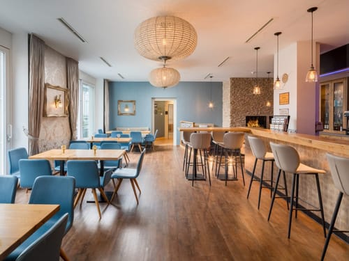 Bar mit Tresen, Barhockern und verschiedenen Tischgruppen