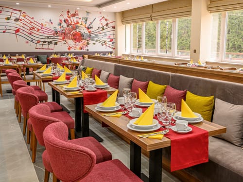 Stilvolles Restaurant-Interieur mit Musik-Wandbild und gedeckten Tischen