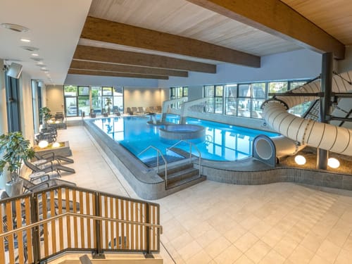 Schwimmbad mit Liegestühlen und Rutsche