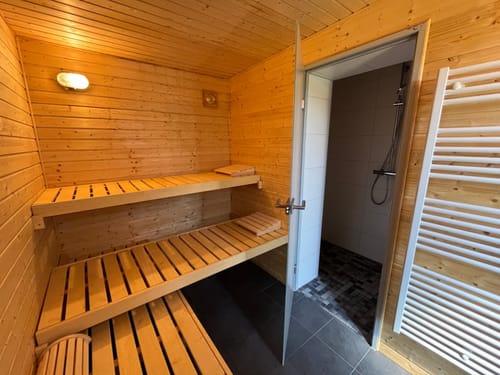 Moderne Sauna mit Holzbänken und angrenzender Dusche