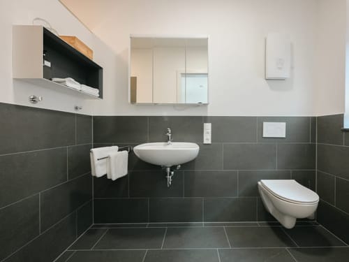 Badbereich mit Waschtisch, Wandspiegel und WC