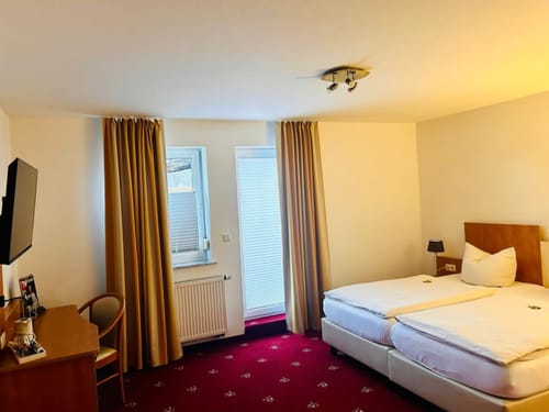 Gemütliches Hotelzimmer mit Doppelbett, Fernseher und Schreibtisch