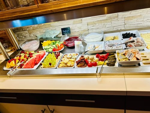 Frühstücksbuffet mit einer Auswahl an frischen Früchten, Joghurt und verschiedenen Häppchen.