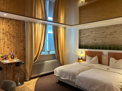 Modernes Hotelzimmer mit zwei Betten, Holzwänden und gemütlicher Beleuchtung