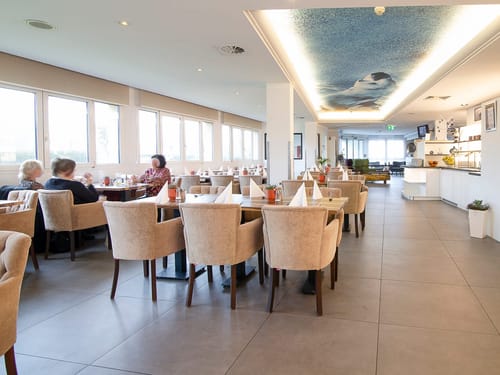 Großes Restaurant mit vielen Tischen und Stühlen