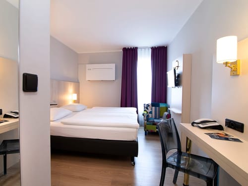 Doppelzimmer mit Sessel, Schreibtisch und Doppelbett