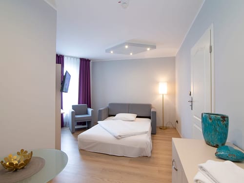 Ausziehbare Couch, Komode und ein TV