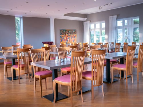 Großer Frühstücksraum mit eingedeckten Tischen