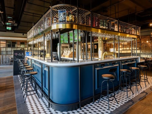 Bar mit Barhockern und verschiedenen Getränkeflaschen