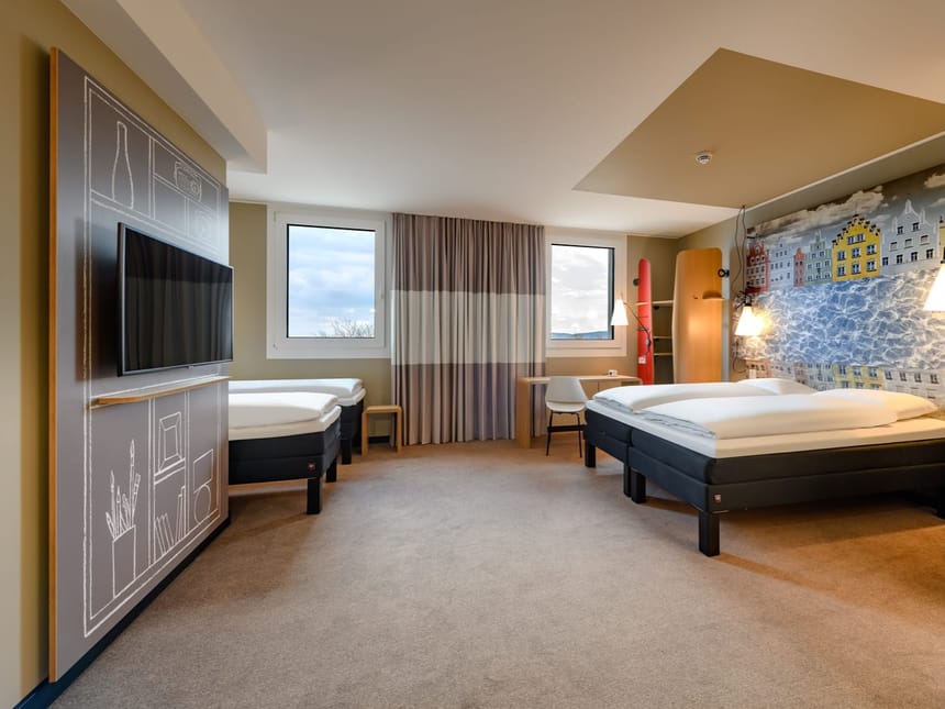 Großes Zimmer mit Schreibtisch und TV