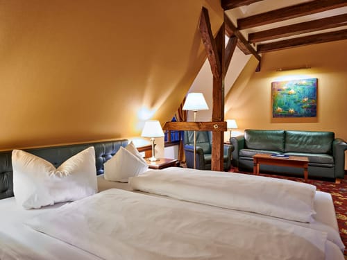 Gemütliches Hotelzimmer mit Doppelbett und gemütlicher Sitzecke