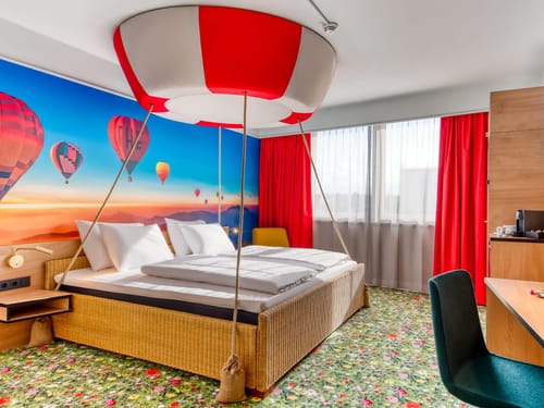 Zimmer mit einem Schreibtisch, Stühl und TV