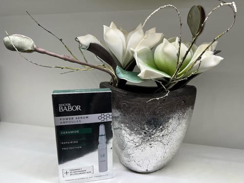Blume in einer Vase und Pflegeprodukte