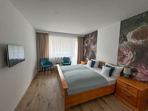 Zimmer mit TV, Tisch und zwei Stühlen