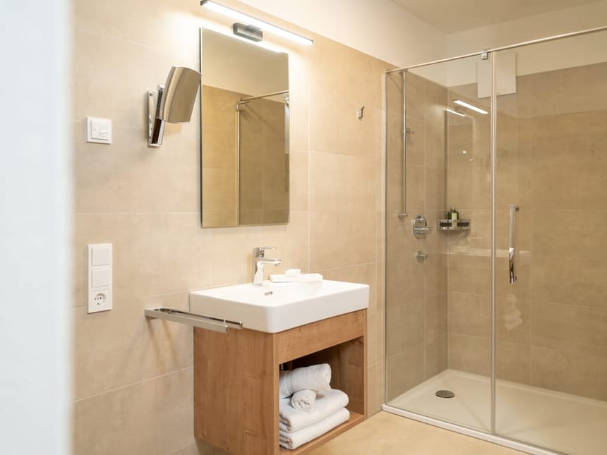  Badbereich mit Dusche, Waschtisch, und Wandspiegel