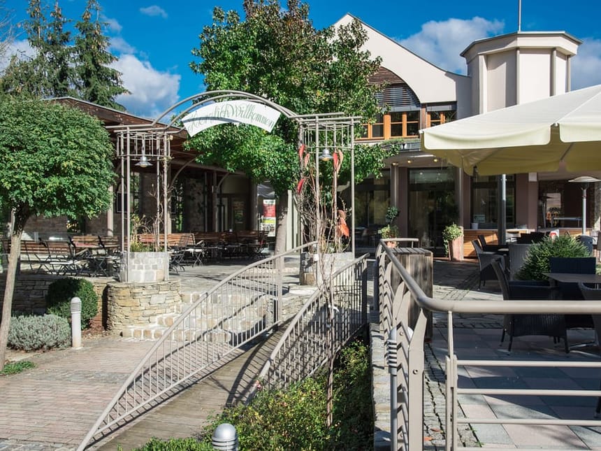 Einladende Restaurantterrasse mit komfortablen Sitzgelegenheiten, Heizpilzen und einem wunderschönen Blick auf die umliegende Natur und Berge