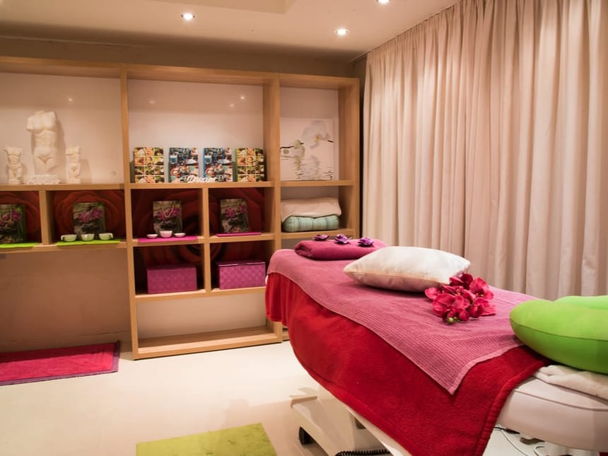 Spa-Behandlungsraum mit Massageliege und stimmungsvoller Dekoration