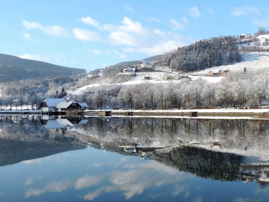 Verschneite Winterlandschaft mit Seespiegelung