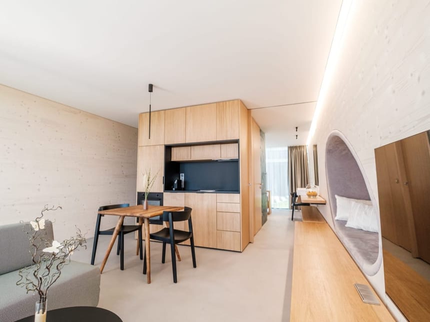 Stilvolle Lodge mit offener Küchenzeile, Essbereich, ovaler Schlafnische in modernem Holz-Design und TV