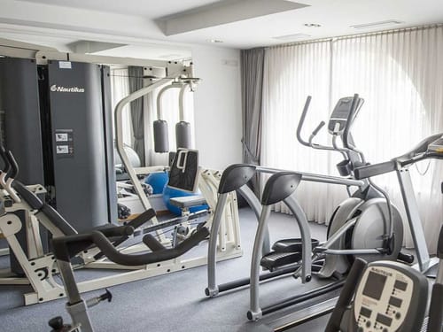 kleiner Trainigsraum mit verschiedenen Cardio und Kraftgeräten