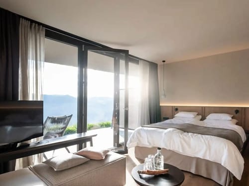 geräumiges Doppelzimmer mit Boxspringbett, Couch, TV und Balkon
