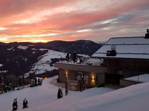 Winterlandschaft mit Haus und spektakulärem Sonnenuntergang im Schwarzwald