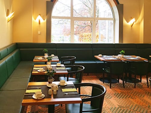 verschieden gedeckte Tisch im Frühstückraum