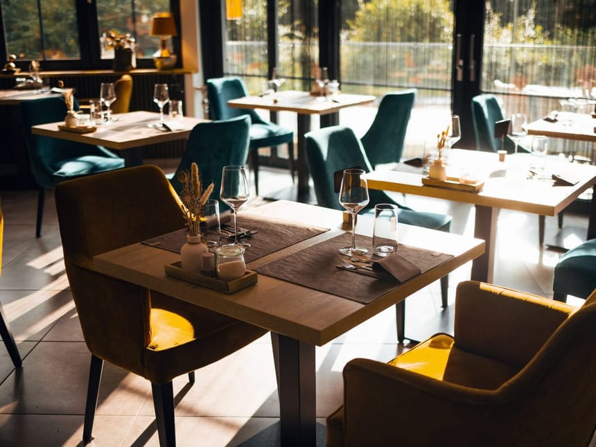 Hotelrestaurant mit verschieden eingedeckten Tischen und Panoramafenstern