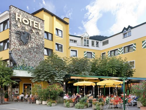 Ansicht Hotel mit Terrasse bei Sonnenschein