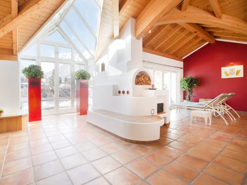 Wellnessbereich mit Kaminofen, Relaxlilegen und Panoramafenstern