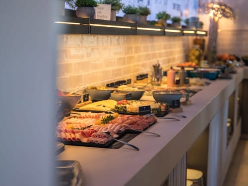 Reichhaltiges Frühstücksbuffet mit verschiedenen Aufschnitten und Käsesorten.