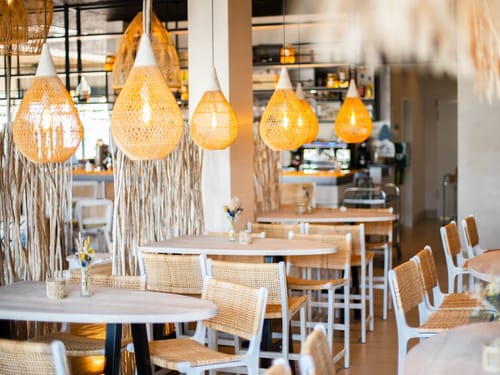 Stilvolles Café mit Rattanmöbeln und gemütlichen Lampen