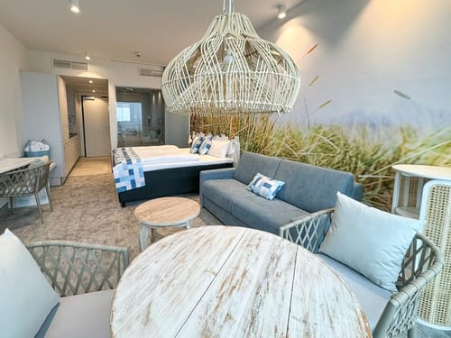 Stilvolles Hotelzimmer mit Doppelbett, Sofa und rustikalem Dekor.