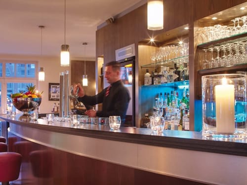 Hotelbar mit Barkeeper und Barhockern