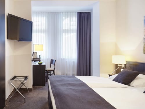 Doppelzimmer mit Doppelbett, Schreibtisch, Stuhl und TV