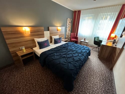 Komfortables Hotelzimmer mit Doppelbett, stilvoller Einrichtung und modernen Möbeln.