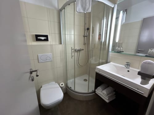 Modernes Badezimmer mit Dusche, Waschbecken und Toilette.
