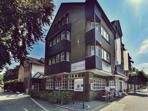 Außenansicht eines modernen Stadthauses bei sonnigem Wetter.