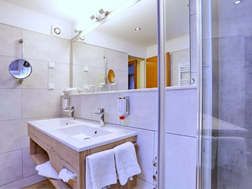 Badezimmer mit Doppelwaschbecken und großer Spiegelwand