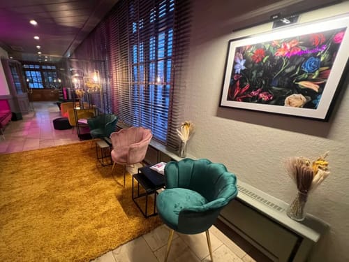 Stilvolles Wartezimmer mit bunten Sesseln und moderner Kunst an der Wand