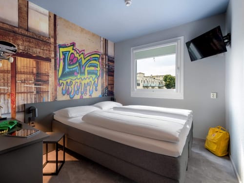 Modernes Hotelzimmer mit Graffiti-Wanddekoration und Ausblick