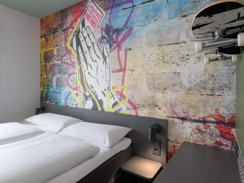 Modernes Hotelzimmer mit Graffiti-Wandkunst und Skateboard-Dekoration.