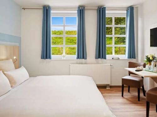 Helles Zimmer mit TV, Schreibtisch und Stühlen