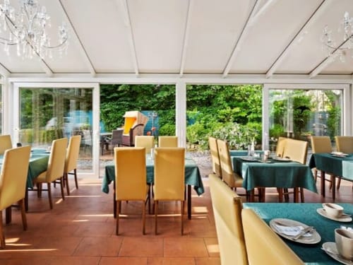 Wintergarten mit eingedeckten Tischen