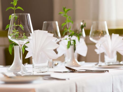 Festliche Tischdekoration mit weißen Servietten und Weingläsern – elegantes Restaurant-Setting