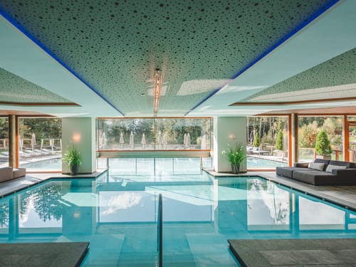 Luxuriöses Hallenbad im Wellnesshotel – Indoor-Pool mit Gartenblick