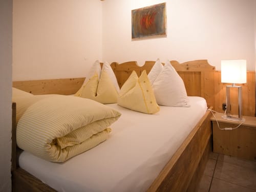 gemütliches Doppelzimmer mit Doppelbett und Stehlampe