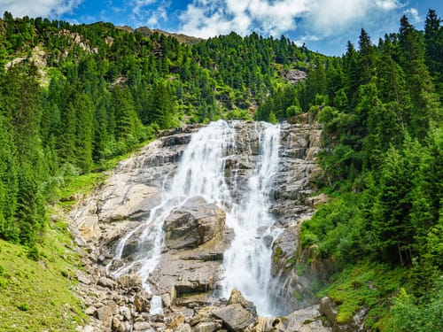 sonniger Tag in den Bergen mit einem Wasserfall
